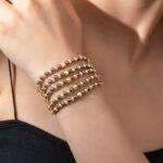 Stapelbares Armband-Set – 5-teilig, glänzend in Gold und Grau, dehnbar in Kugeldesign